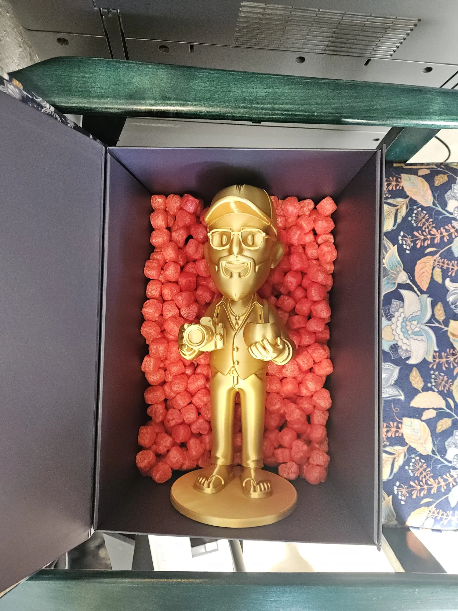 Złota figurka w pudełku prezentowym